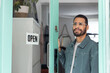 © ReeldealHD images - Retail shop owner at entrance proudly showing open sign