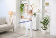 © New Africa - Beautiful young woman exercising with hula hoop at home