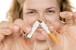 © vladimirfloyd - Young woman breaking cigarette in half, smiling confidently. Symbolizing quitting smoking, health awareness, and personal triumph over addiction