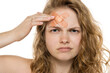 © vladimirfloyd - Thoughtful portrait of young woman with bandage on forehead, curly blonde hair. Close-up, white background.