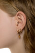 © vladimirfloyd - Close-up of ear with multiple gold earrings, showing delicate piercing details. Side view of blonde hair, soft skin texture. Minimal, elegant jewelry styling