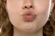 © vladimirfloyd - Close-up of young woman making pucker or kissing gesture. Plump lips, natural texture, soft focus. Playful, expressive facial expression showcasing emotion