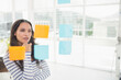 © Wavebreak Media - Female professional standing in modern meeting room examining sticky notes on glass partition
