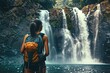 © fariqyahya - Vibrant Picture of Rear View of Female Backpacker Enjoying Amazing Tropical Waterfall