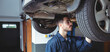 © Wavebreak Media - Male mechanic inspecting vehicle underside on hydraulic lift near wheel well in repair workshop