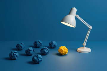 Poster - Innovation and focus are highlighted by a single yellow paper ball illuminated on a blue surface symbolizing creative problem-solving in business environments