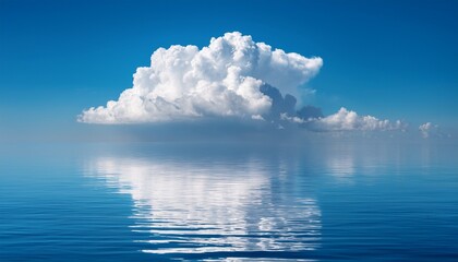 scenic seascape with a big white cloud in the blue sky reflecting over the ocean horizon on a bright