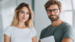 © LightCraft - Smiling young couple standing together in bright modern office, holding documents, casual clothing, natural light, confident and relaxed atmosphere