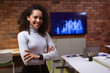 © Wavebreak Media - Woman in business attire crossing arms in office by skyline screen, laptop and pencil holder