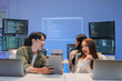 © whyframeshot - Asian programmers collaborating on software development at night, focused on writing code across multiple monitors in a tech office environment  Programmers Collaborating on Software Development