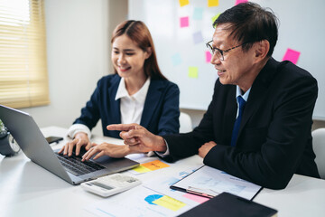 Poster - Two people are sitting at a desk with a laptop open