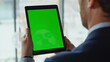 © stockbusters - Ceo looking chromakey tablet reading financial report in office closeup.