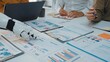 © InfiniteFlow - A collaborative workspace scene featuring a robot hand interacting with financial reports and charts while humans engage in analysis and strategy discussion.Noogenesis