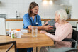 © zinkevych - Nurse checking the blood pressure of an elderly lady