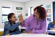 © Wavebreak Media - Female teacher and girl high-fiving in classroom, celebrating success and teamwork, at school