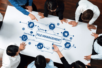Poster - A diverse team collaborates around a table, strategizing file management solutions. Highlighting cloud storage, backup, and data organization for improved workflow and productivity. Amity