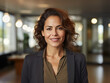 © ZaynMorgan - Mujer mexicana de mediana edad con expresión amable y profesional posando en primer plano dentro de una oficina moderna con iluminación natural y ambiente corporativo.