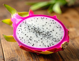 Vibrant halved dragon fruit with white flesh and black seeds on rustic wooden table