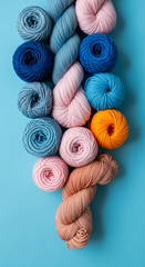 Leinwandbilder - Close-up of pastel yarn balls arranged on blue background, showcasing various shades of pink, blue, and orange.  A soft, textured display, ideal for craft or hobby projects. Free space available