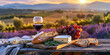 © Ekaterina Pokrovsky - French cheese plate, fresh baguette and a glass of red wine on a wooden table, with lavender fields of Provence in the background.