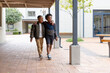 © Wavebreak Media - Two diverse boys walking together in school courtyard, enjoying friendship and conversation
