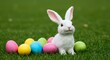 © Frame Stocks - White Easter Bunny Figurine with Colorful Eggs on Green Grass