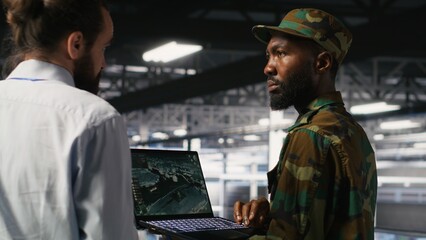 Poster - Soldier in server room uses geospatial data to support evacuation during emergency operations. Military data center personnel in uniform coordinating disaster response logistics using laptop