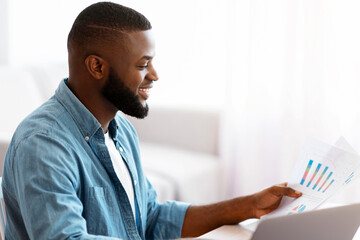 Poster - Remote Business. Young Black Entrepreneur Working With Papers And Laptop At Home Office, Smiling African American Businessman Sitting At Desk And Reading Financial Doucments, Enjoying Remote Job