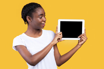Aufkleber - African American Woman Showing Digital Tablet With Blank Computer Screen Advertising Website Or Application Posing Standing Over Yellow Background In Studio. Modern Lifestyle, Gadgets And Technology