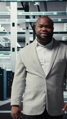 Poster - vertical video smiling manager in data center doing checkup on hardware to avoid downtime. happy afr