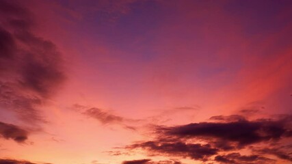 Wall Mural - A sunset timelapse showcasing a gradient sky from soft pinks to deep purples, with scattered clouds gently shifting, creating a peaceful transition from day to night filled with calm and warmth.