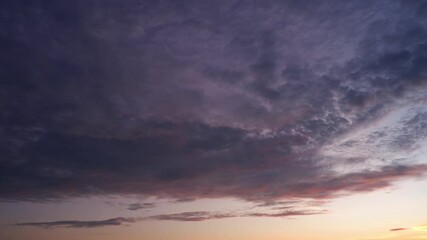 Wall Mural - A breathtaking sunrise timelapse showing dark clouds slowly glowing with warm orange and pink hues as the sun rises, illuminating the sky and signaling the start of a vibrant new day. Time-lapse.
