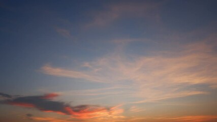 Wall Mural - A serene sunset timelapse with soft purple and pink hues spreading across the sky, wispy clouds gently drifting, creating a peaceful and calming end to the day’s light and warmth. Time-lapse.
