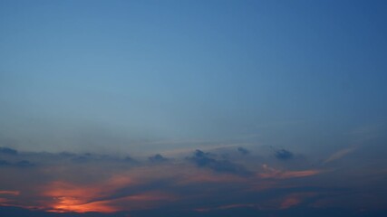 Wall Mural - A sunset timelapse capturing the glowing sun dipping below the horizon, painting soft orange and pink hues across a partly cloudy sky, evoking calm and the gentle close of the day. Time-lapse.
