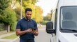 © phj.domingos - Delivery driver using phone next to van for logistics and transportation services in urban area street