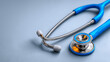 © Abd - Medical blue stethoscope close-up: Metallic sheen components with white-blue color blocking on light gray backdrop. Professional healthcare tool visual for educational materials, clinic promotions, or