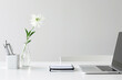 © Liew - A modern workspace showcases a laptop, a notebook, and a single flower in a glass vase