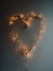 Poster - Heart-shaped String Lights Create a Warm Ambiance on a Neutral Wall for Cozy Decor and Romantic Settings