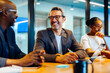 © (JLco) Julia Amaral - Business professionals talking and smiling during a meeting in a conference room