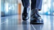 © Dmitriy - Man in business attire walks confidently on a sleek tile floor in an office environment, showcasing polished shoes