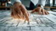 © Nadiatul - Senior architect reviewing the blueprint of building project with focus and detail