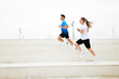 © muse studio - Couple Enjoys an Energetic Workout Session, Sprinting up Steps in an Outdoor Park on a Bright, Overcast Day