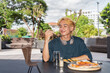 © Ranta Images - Thai gay teen male eating pepperoni pizza in outdoor restaurant