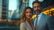 © Bussakon - Confident business couple posing in modern office with city skyline