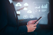 © Kampan - Businessman using smartphone with virtual AI and cloud computing icons, representing digital transformation and modern data analytics