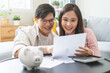 © KMPZZZ - Happy asian young couple love, wife, husband calculate income and planning, saving money to buy real estate for new home. Business finance, deposit with banking for financial planning future together.