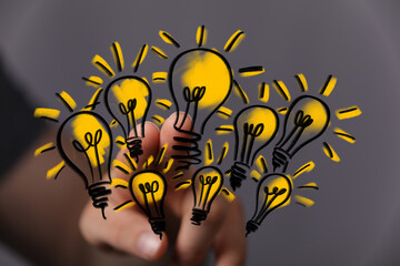 Poster - Image of a hand selecting multiple glowing lightbulb ideas, symbolizing innovation and creativity.