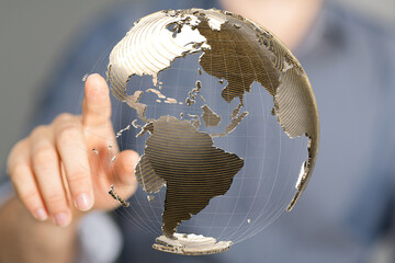Poster - Person's finger interacts with a digital globe, symbolizing global connectivity and networking.
