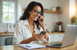 © Pete - Smiling woman talks on phone, using smartphone, working from home. Female entrepreneur with laptop, notebook, glasses. Remote work, planning, startup company strategy, business communication, online,