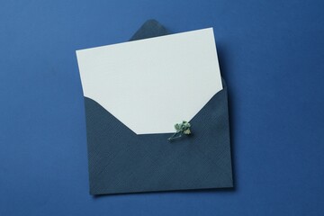 Wall Mural - Blank invitation card and envelope on blue background, top view. Space for design